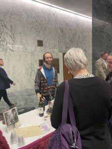 With a smile, Larry speaks with wine tasters at the Frontenac tasting table at the exhibition